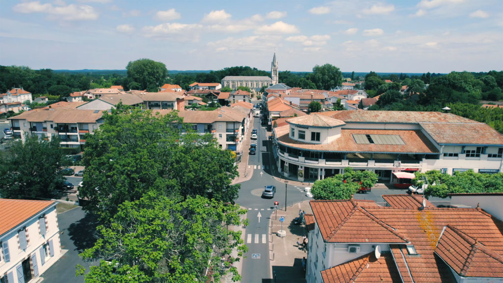 Centre ville de Soustons dans les Landes vu au drone avec une rue commerçante et une église