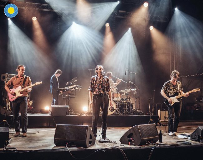 Un groupe de rock en concert avec Arthur Teboul sur scène